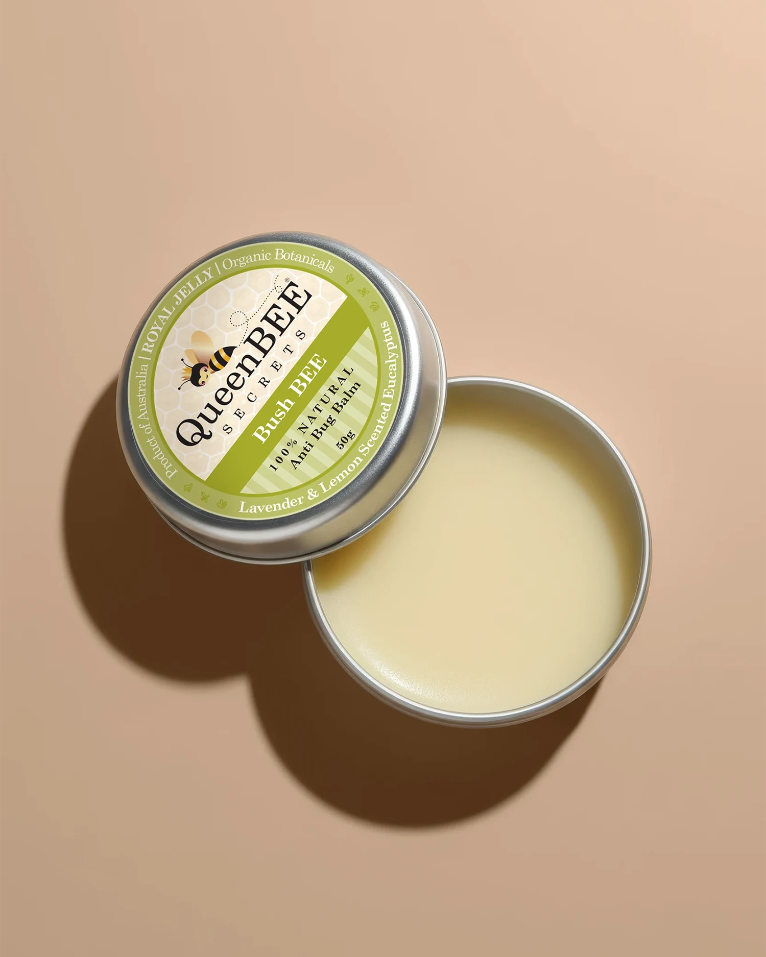 Open tin of Queen Bee balm on a beige background