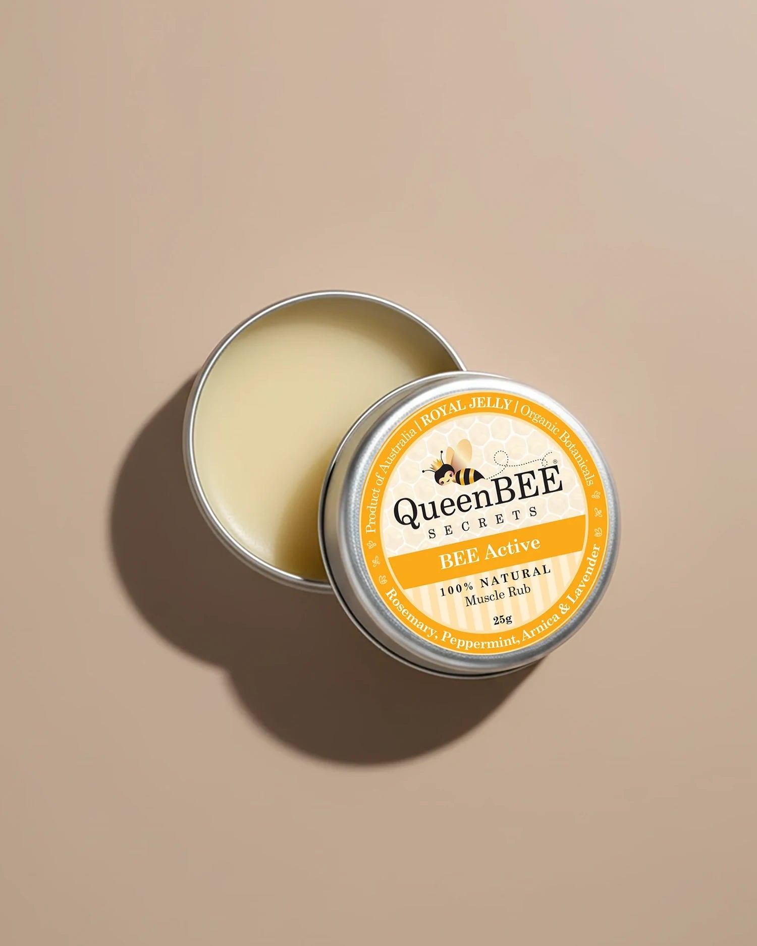 QueenBEE Secrets BEE Active muscle balm in a metal tin on a beige background