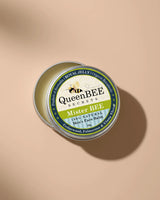 QueenBEE Secrets Mister BEE men's face balm tin on a beige background
