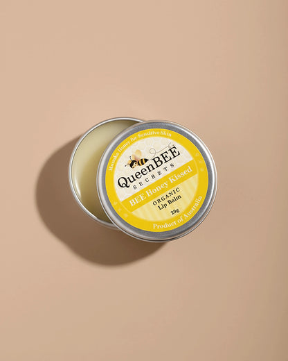 QueenBEE lip balm tin on a beige background