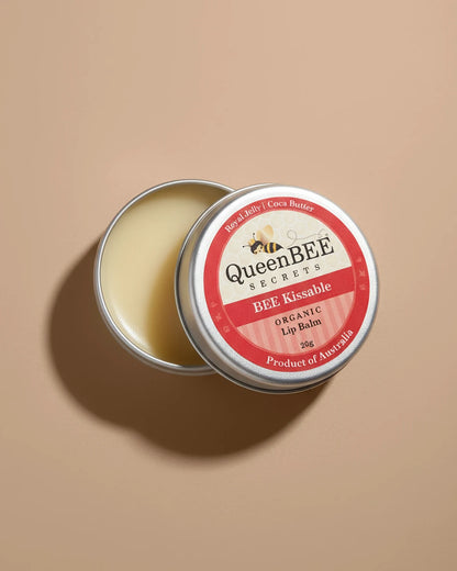 Queen Bee Secrets lip balm tin on a beige background