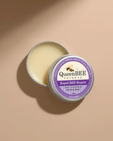 QueenBEE Secrets Rapid BEE Repair balm in a tin on a beige background