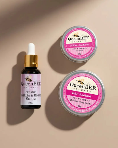 QueenBEE Secret skincare products including serum, eye balm, and face balm on a beige background