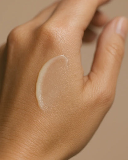 Hand with a small amount of balm against a neutral background